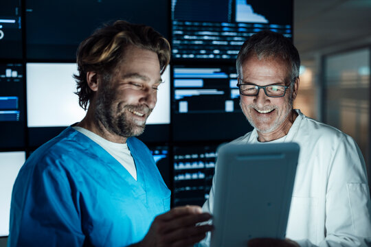 Doctors reviewing data analysis on a tablet at the hospital