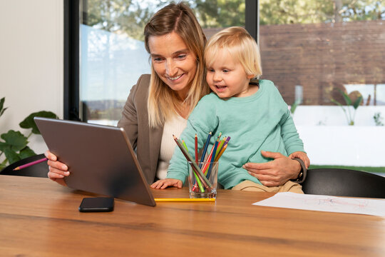 Freelance mother and son with tablet PC at home