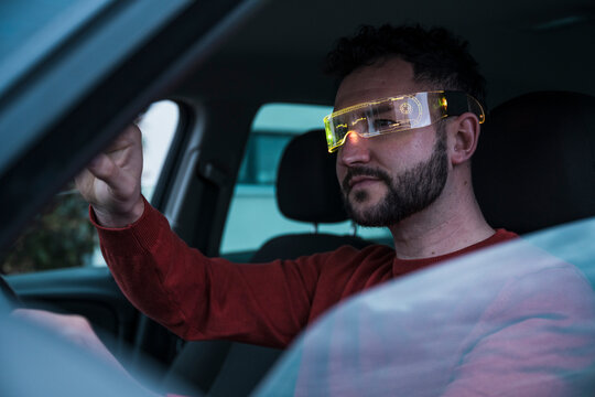 Smiling man wearing smart glasses in car
