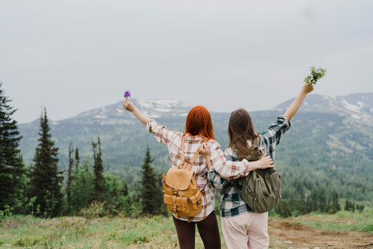 Tourist friends with backpacks hug in Sheregesh mountains