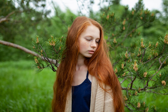 Long red hair and freckles outdoors in summer nature