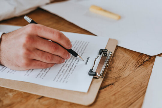 Businessman signing agreement at desk
