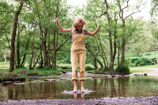 Happy woman jumping in river water