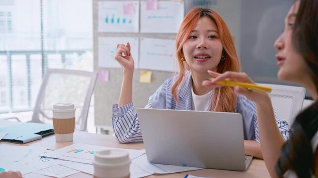 Asian businesswoman listening in team meeting discussion in modern office