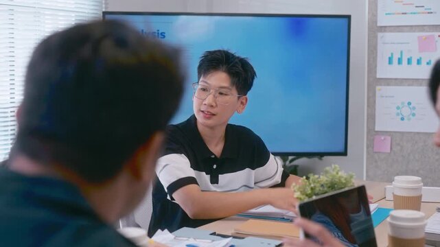 Young Asian colleagues teamwork in modern office space Discussing market trends and conducting data analysis to develop a successful business strategy together