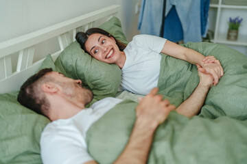 Obraz premium Happy couple relaxing together in bed in bedroom