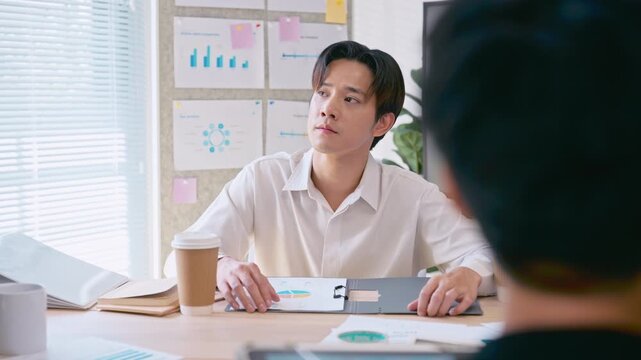 Asian businessman listening in team meeting discussion in modern office