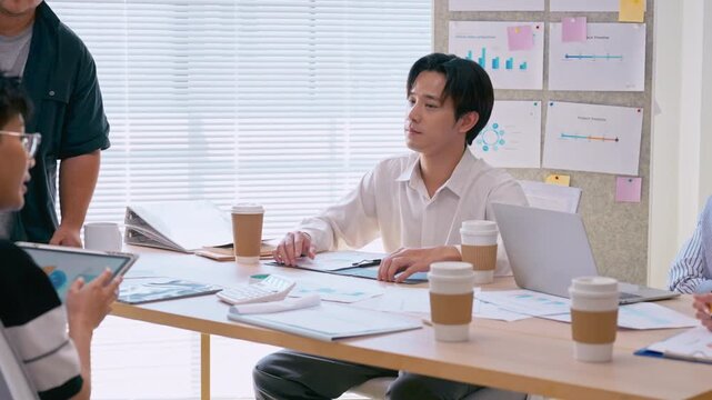 Asian businessman listening in team meeting discussion in modern office