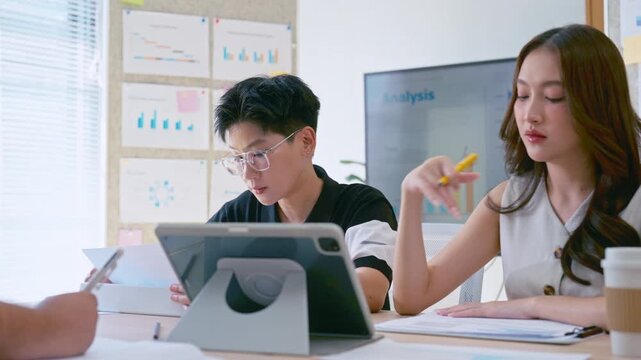 Asian businessman listening in team meeting discussion in modern office