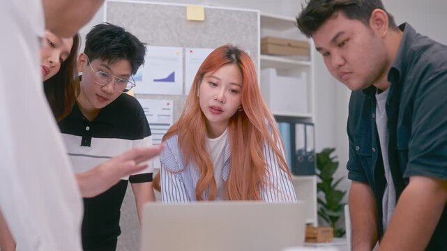 Young Asian colleagues teamwork in modern office space Discussing market trends and conducting data analysis to develop a successful business strategy together