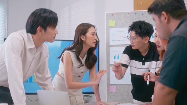 Creative young Asian business team meeting to brainstorm innovative ideas for a new venture, showing teamwork, leadership, and startup energy presentation project in a modern office.