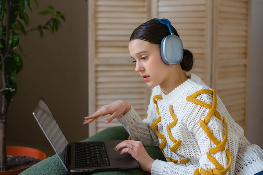 Young girl student communicating online while attending virtual class at home