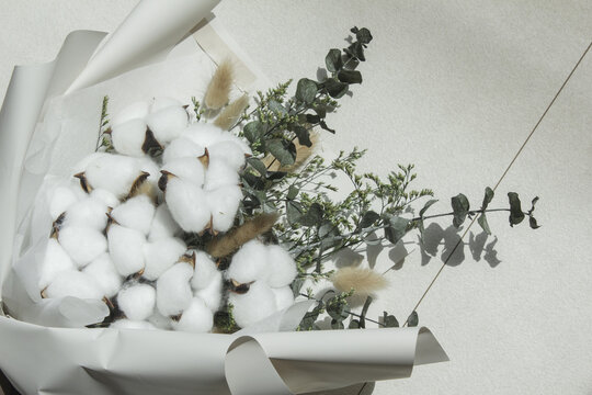 It is a bouquet of cotton flowers placed against a white background.