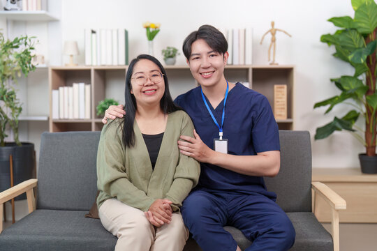 Asian man caregiver and woman patient smiling in home healthcare setting