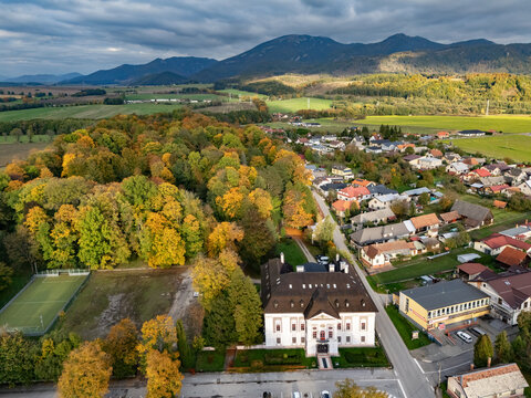 Aerial view of the baroque-classicist mansion with its pristine white facade amid the vibrant autumn foliage, nestled near the majestic mountain range, Mosovce, Zilina Region, Slovakia.