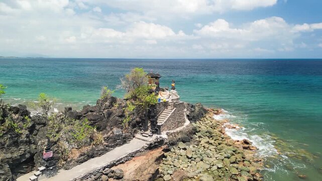 Stunning overhead panorama of Batu Bolong temple near Senggigi beach featuring Balinese architecture black lava rock and turquoise sea