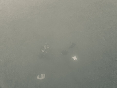 Aerial view of a landscape lost in thick, grey-green fog, with faint dark and light shapes barely visible, Obudu, Cross River, Nigeria.