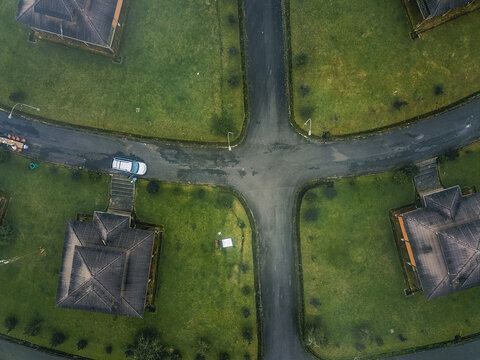 Aerial view of dark-roofed buildings set against vibrant green lawns, connected by curving asphalt roads, Obudu, Cross River, Nigeria.