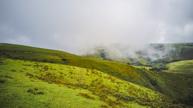 Aerial view of serene, verdant rolling hills partially shrouded in ethereal mist, Obudu, Cross River, Nigeria.