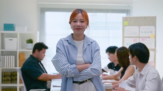 Portrait young Asian business woman with team in a modern office meeting startup seminar, teamwork, and training session, showing collaboration, professionalism, and creative business environment.
