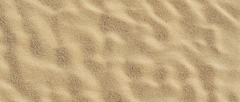 Wet golden beach sand background top view &ndash; aerial image of tropical shore surface as a backdrop texture on a blank panoramic wide background.

