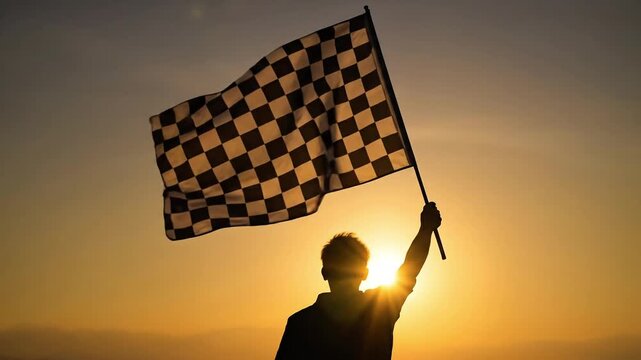 Silhouette of person holding checkered flag at sunset, symbolizing victory and achievement.