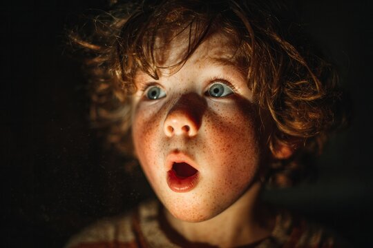 Close-up of a freckled child expressing surprise