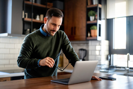 Success man typing on laptop, communicating online distantly working or studying on computer at home
