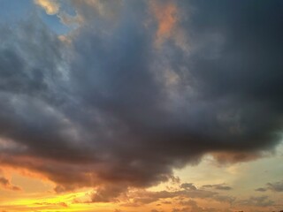 Obraz premium Dramatic sunset sky with vibrant orange and dark clouds at dusk