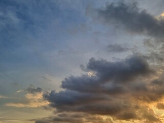 Obraz premium Dramatic sunset sky with vibrant orange and dark clouds at dusk