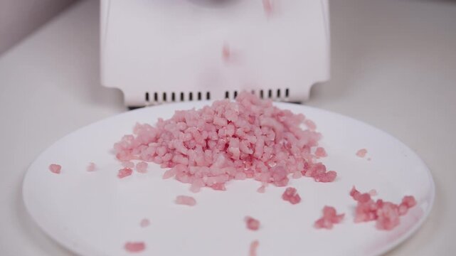 Pink minced pork on platter. Witness texture and cleanliness of meat preparation details. Prepare food with care as meat is processed and hygiene is prioritized in kitchen