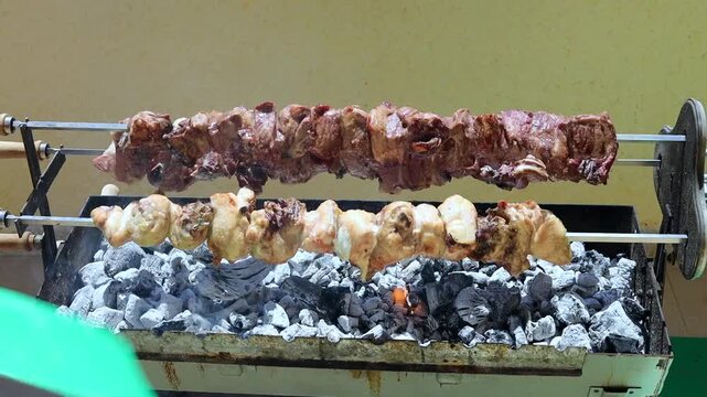 Close-up of charcoal being heated and prepared for barbecue cooking. Flames and glowing coals building up heat, showing the essential preparation stage before grilling begins.
