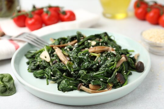 Delicious spinach with shimeji mushrooms served on light table, closeup