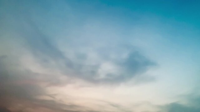 4K footage of soft pastel sunset sky with layered clouds, warm peach and blue gradient, eye level wide angle, smooth focus, calm mood. Ideal for nature, background, serenity, weather, and cinematic th
