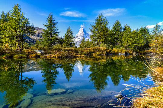 The iconic Matterhorn mountain in Zermatt, Switzerland, reflected perfectly in a lake. 