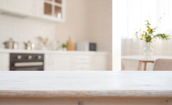 Empty bleached wood tabletop counter on interior of bright blurred kitchen interior background