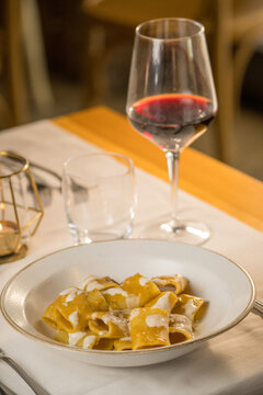 Gourmet presentation of traditional Italian paccheri pasta coated in a rich, creamy cheese sauce. The image highlights the large, tube-shaped pasta perfectly cooked and smothered in a velvety melted c