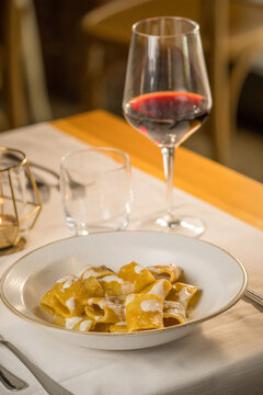 Gourmet presentation of traditional Italian paccheri pasta coated in a rich, creamy cheese sauce. The image highlights the large, tube-shaped pasta perfectly cooked and smothered in a velvety melted c