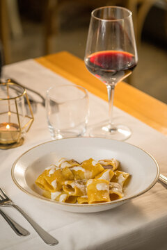 Gourmet presentation of traditional Italian paccheri pasta coated in a rich, creamy cheese sauce. The image highlights the large, tube-shaped pasta perfectly cooked and smothered in a velvety melted c
