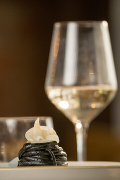 Gourmet presentation of Italian spaghetti with squid ink served on a restaurant table. 