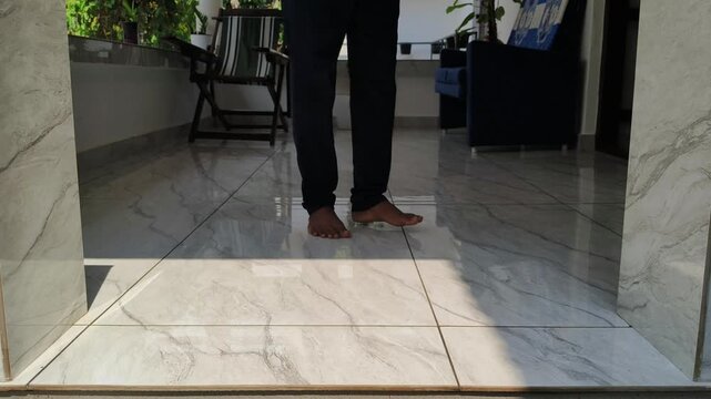 Indian online shopping customer hand collect or take brown cardboard box parcel package from doorstep. Courier service, home delivery, postal business, ecommerce and quick commerce concept.