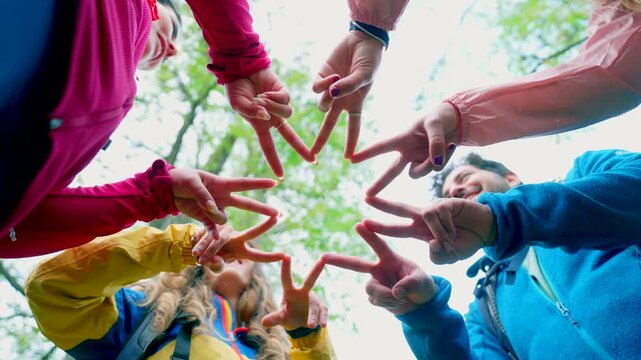 Group of hikers forming a star shape with hands. Group of smiling friends making a star with their hands in a circle as a symbol of unity