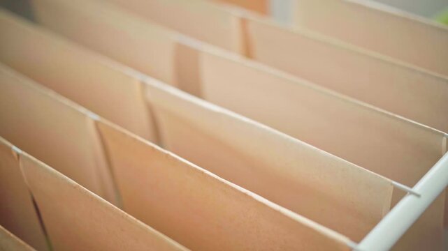 Tea-stained paper sheets drying on rack, crafting process, ideal for artistic projects or vintage-themed designs. Aging paper with tea, home crafting, educational workshops, diy