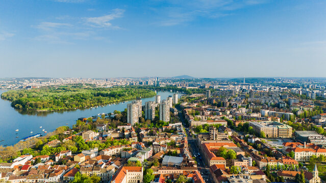 Aerial view of the historic Zemun district featuring red-roofed houses, the Danube river, and the lush Great War Island Belgrade, City of Belgrade, Serbia.