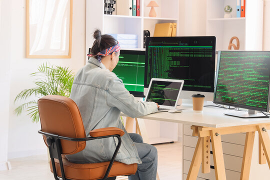Female programmer working with laptop at desk in office