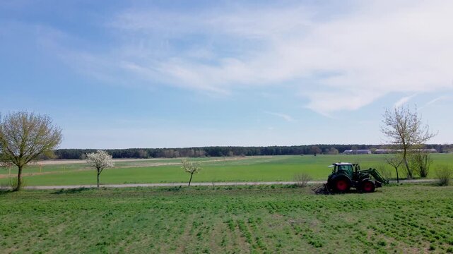 Gr&uuml;ner Traktor f&auml;hrt auf Feld