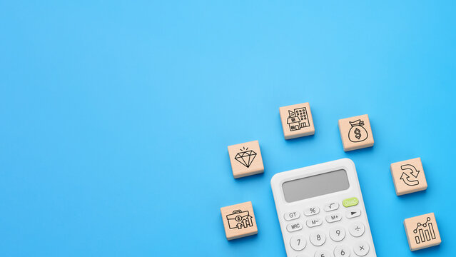 Calculator with wooden blocks and investment icons for capital growth
