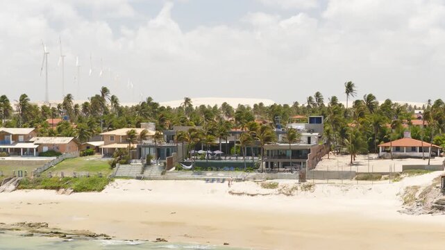 Carmel Ta&iacute;ba Exclusive Resort Praia da Ta&iacute;ba S&atilde;o Gon&ccedil;alo do Amarante Cear&aacute; Brazil with beachfront villas palm grove and Atlantic shoreline, drone pullback shot