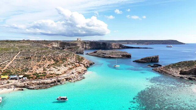 Blue Lagoon Bejn il Kmiemen Comino Għajnsielem Gozo and Comino District Malta between Comino and Cominotto with shallow limestone seabed reef patches and St Mary Tower in background Mediterranean Sea