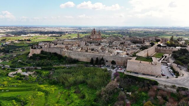 Mdina, MaltaMdina Northern Region Malta walled medievaMdina Northern Region Malta walled medieval city with St Paul Cathedral and bastions overlooking Rabat and agricultural landscape aerial orbit